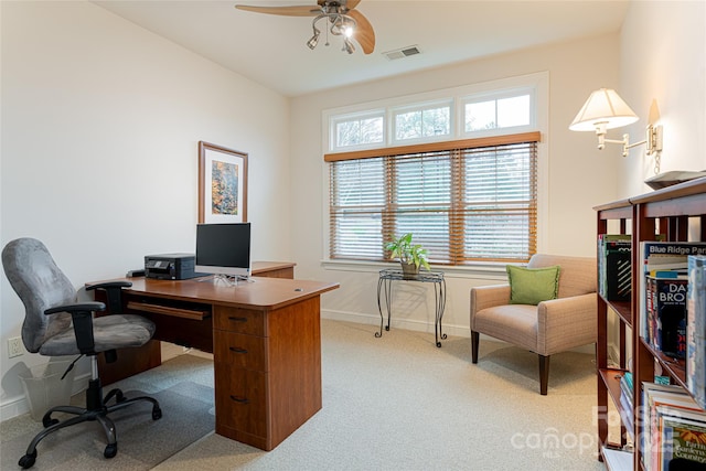 office featuring baseboards, ceiling fan, visible vents, and light colored carpet