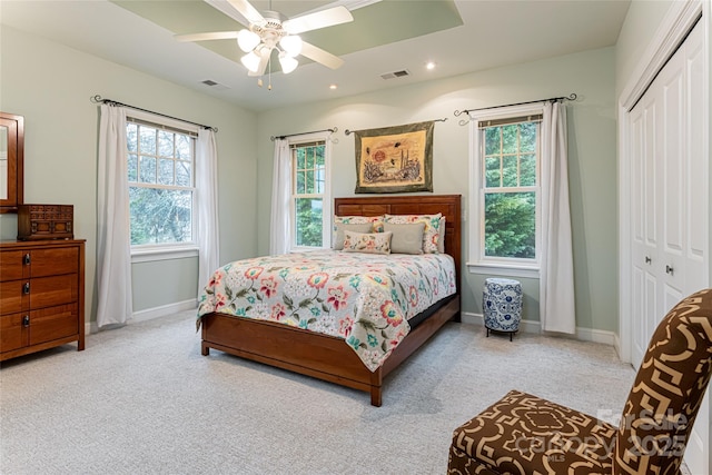 bedroom featuring a closet, visible vents, baseboards, and multiple windows