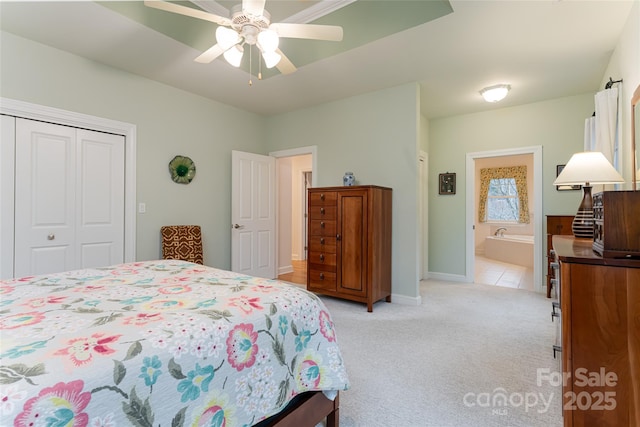 bedroom with light carpet, baseboards, connected bathroom, a ceiling fan, and a closet