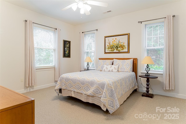 carpeted bedroom with visible vents, ceiling fan, and baseboards