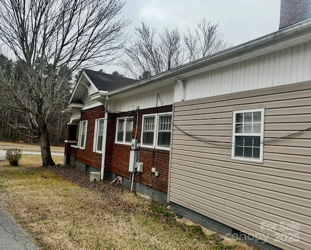 view of side of home with a yard