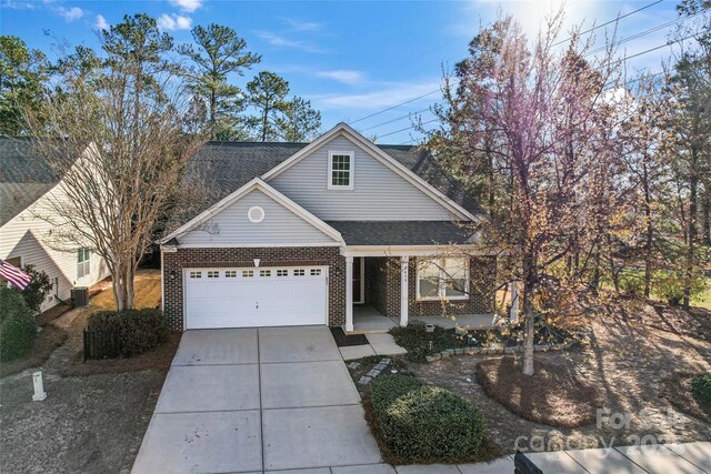 2439 Bergamot St, Fort Mill, SC 29708 - view of front facade with driveway, an attached garage, covered porch, central AC, and brick siding