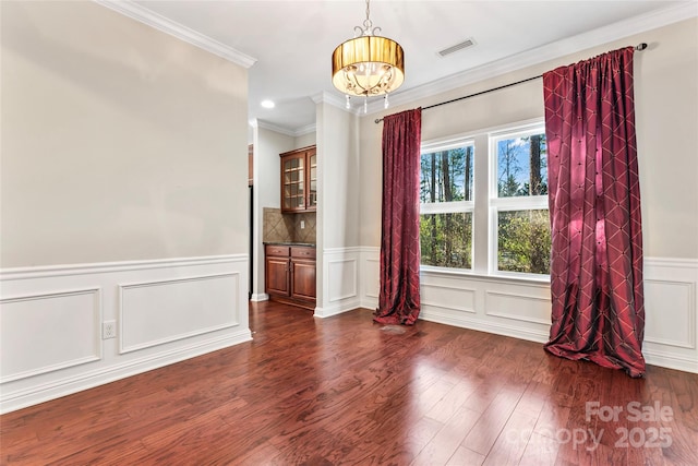 2439 Bergamot St, Fort Mill, SC 29708 - spare room with visible vents, dark wood-type flooring, a chandelier, ornamental molding, and wainscoting
