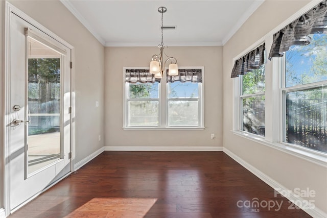 2439 Bergamot St, Fort Mill, SC 29708 - unfurnished dining area with crown molding, baseboards, dark wood-type flooring, and an inviting chandelier