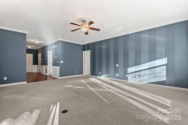 2439 Bergamot St, Fort Mill, SC 29708 - unfurnished living room with wallpapered walls, crown molding, a wainscoted wall, carpet floors, and a ceiling fan