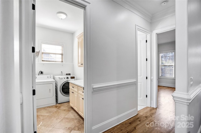 laundry area featuring cabinet space, crown molding, baseboards, and washer and dryer