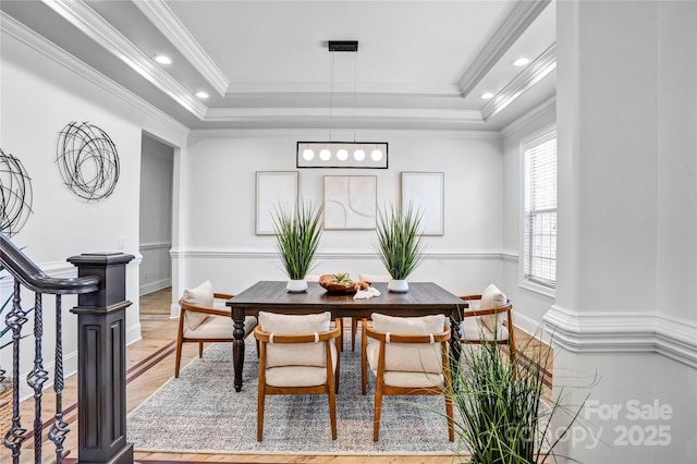 dining room featuring recessed lighting, wood finished floors, stairway, a tray ceiling, and crown molding