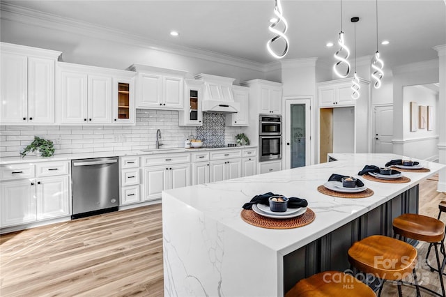 kitchen with glass insert cabinets, white cabinetry, appliances with stainless steel finishes, and a center island