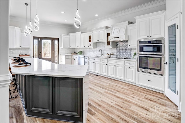 kitchen with appliances with stainless steel finishes, glass insert cabinets, white cabinetry, and pendant lighting