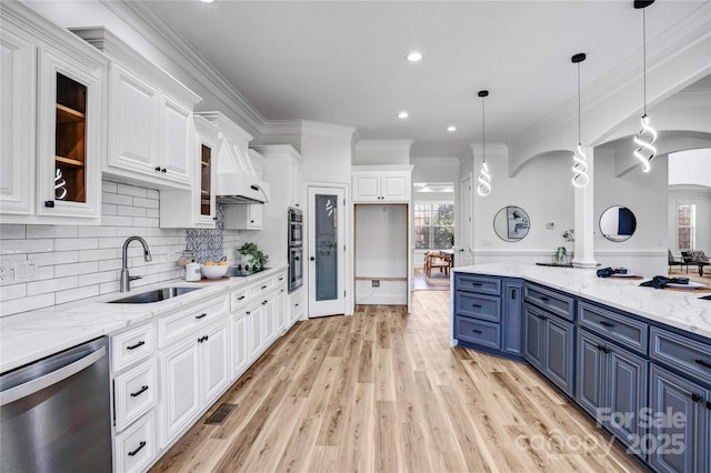 kitchen featuring blue cabinets, a sink, white cabinetry, appliances with stainless steel finishes, and pendant lighting