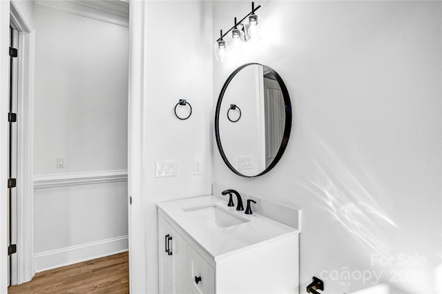 bathroom with wood finished floors, vanity, and baseboards