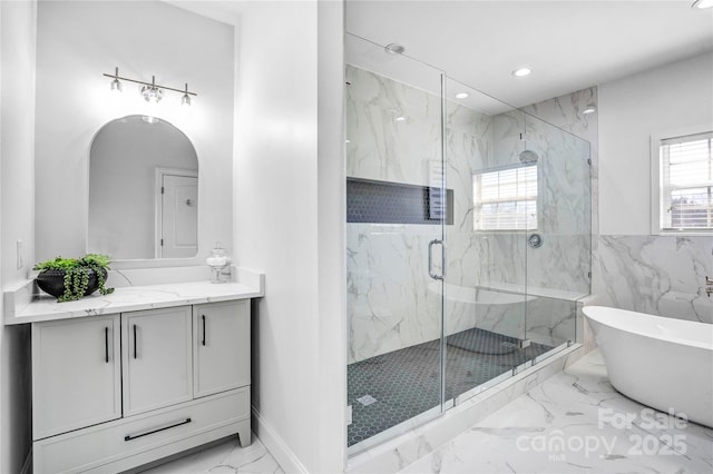 bathroom featuring marble finish floor, a marble finish shower, recessed lighting, a freestanding bath, and vanity