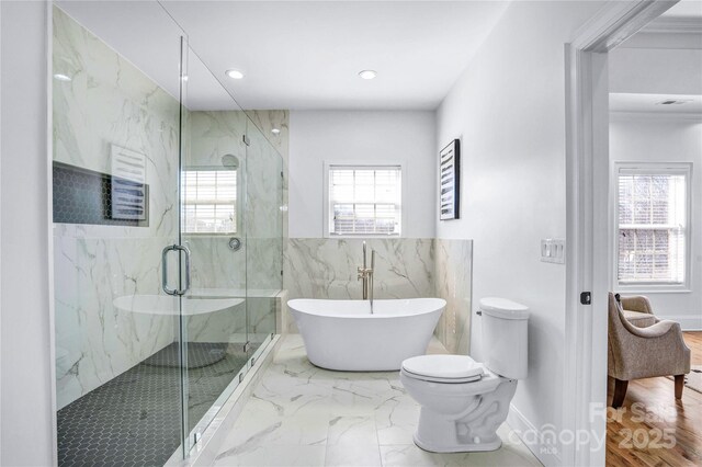 full bathroom featuring marble finish floor, a marble finish shower, recessed lighting, toilet, and a freestanding tub