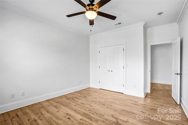 unfurnished bedroom featuring light wood finished floors, visible vents, and crown molding