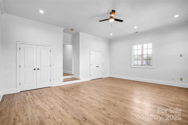 spare room with ornamental molding, light wood-style flooring, and baseboards