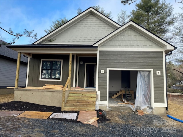 view of front facade featuring a garage, covered porch, and board and batten siding