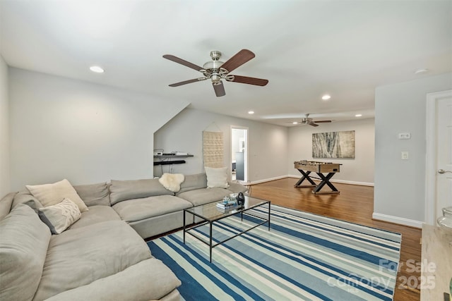 living area with baseboards, wood finished floors, and recessed lighting