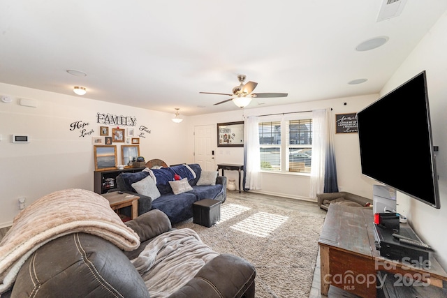 living room featuring ceiling fan, wood finished floors, visible vents, and baseboards