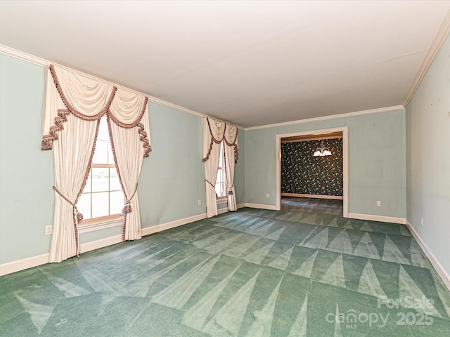 carpeted empty room featuring crown molding and baseboards