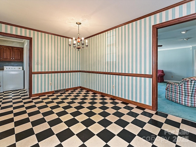 empty room with washer / dryer, a notable chandelier, crown molding, and wallpapered walls