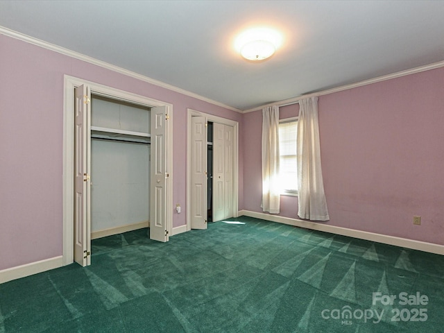 unfurnished bedroom featuring carpet, crown molding, baseboards, and two closets