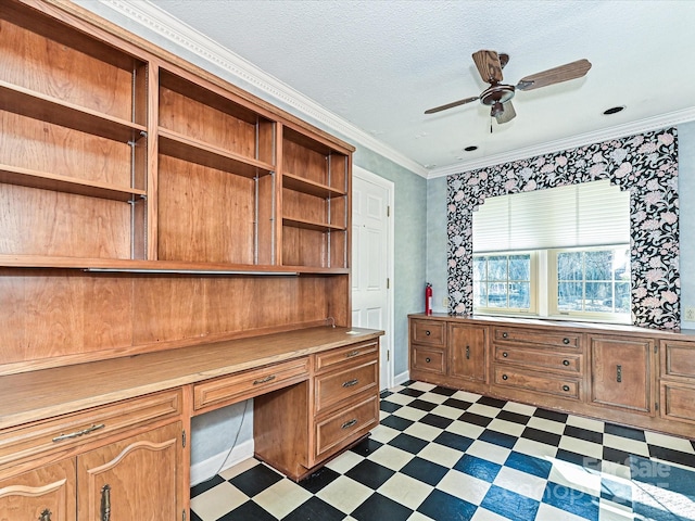 unfurnished office featuring ceiling fan, dark floors, a textured ceiling, built in study area, and crown molding