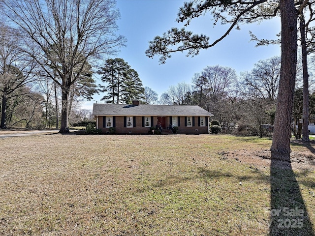 ranch-style house with a chimney and a front lawn