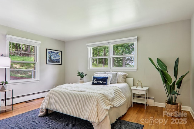 324 Old Leicester Hwy, Asheville, NC 28806 - bedroom featuring baseboard heating, multiple windows, and wood finished floors