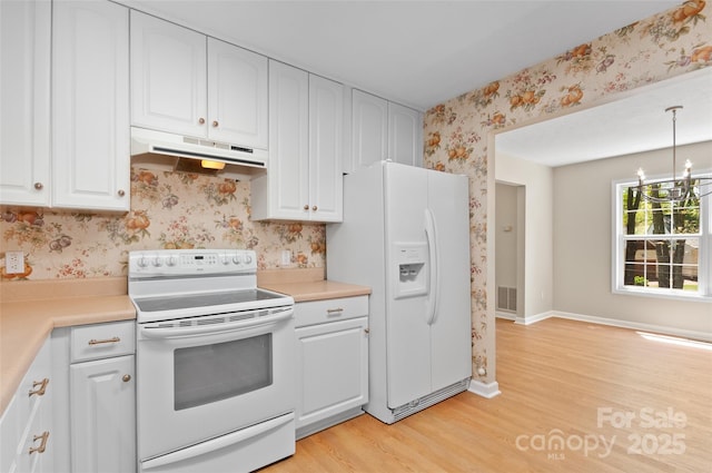 kitchen featuring white cabinets, light wood-style floors, white appliances, wallpapered walls, and under cabinet range hood