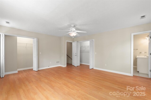 unfurnished bedroom featuring light wood-style floors, baseboards, and visible vents