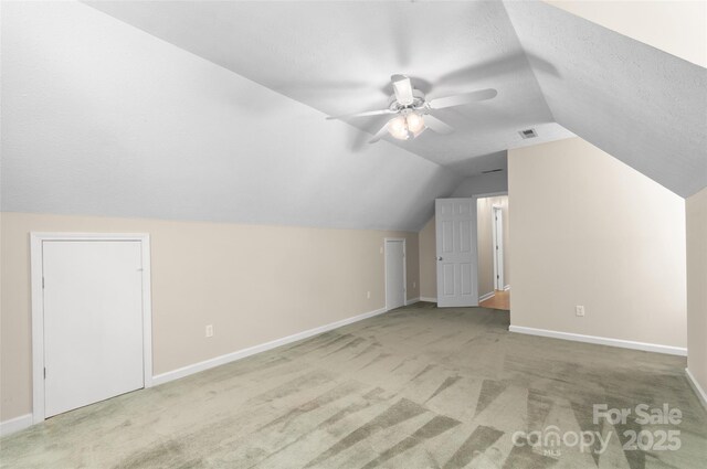 bonus room with carpet floors, visible vents, baseboards, a ceiling fan, and vaulted ceiling