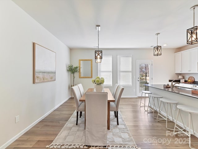 dining space with baseboards and light wood-style floors