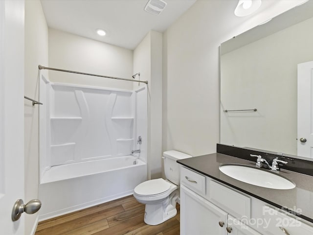 bathroom featuring toilet, wood finished floors, vanity, visible vents, and shower / bathing tub combination