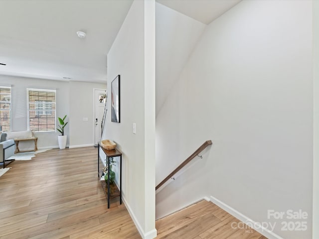 staircase with baseboards and wood finished floors