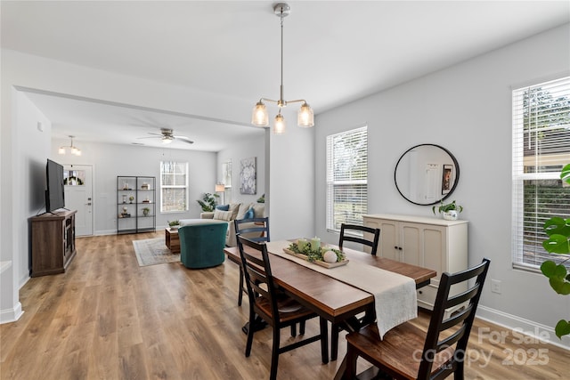 dining space with baseboards, wood finished floors, and a healthy amount of sunlight