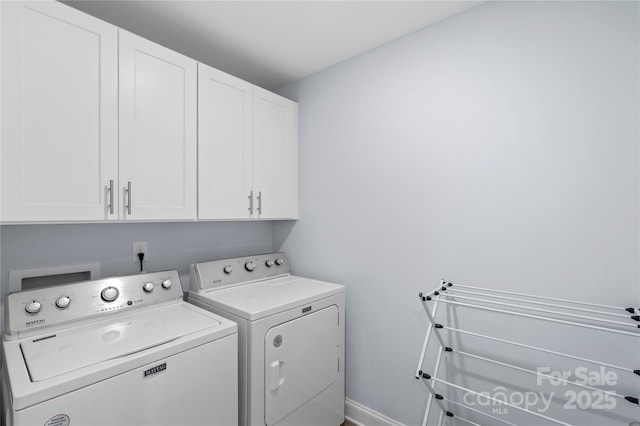 washroom with cabinet space, baseboards, and washing machine and clothes dryer