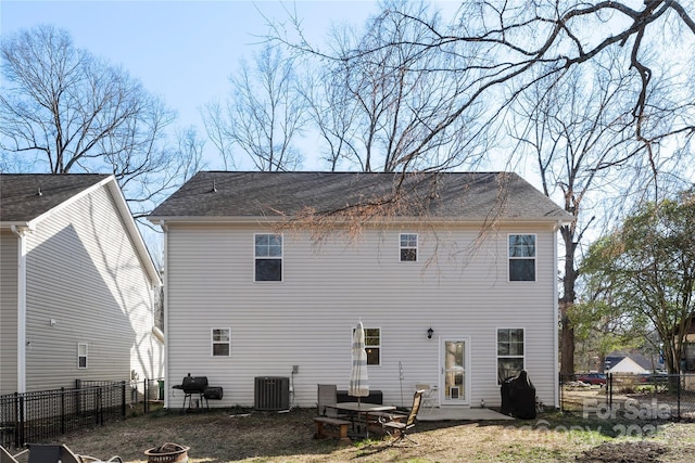 rear view of house featuring central AC unit, a patio area, a fenced backyard, and a fire pit