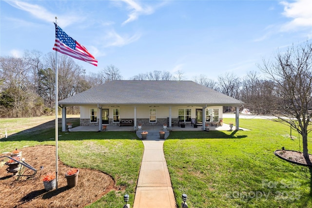 back of house featuring stone siding, a patio area, and a yard