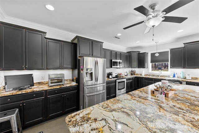 kitchen with appliances with stainless steel finishes, dark cabinetry, visible vents, and light stone counters