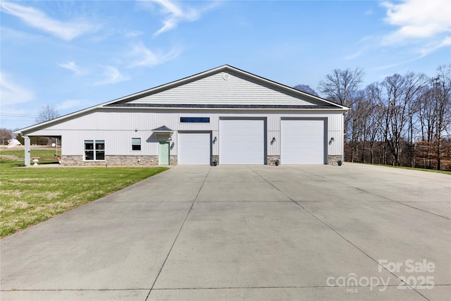 view of front of property featuring a garage, stone siding, driveway, and a front lawn