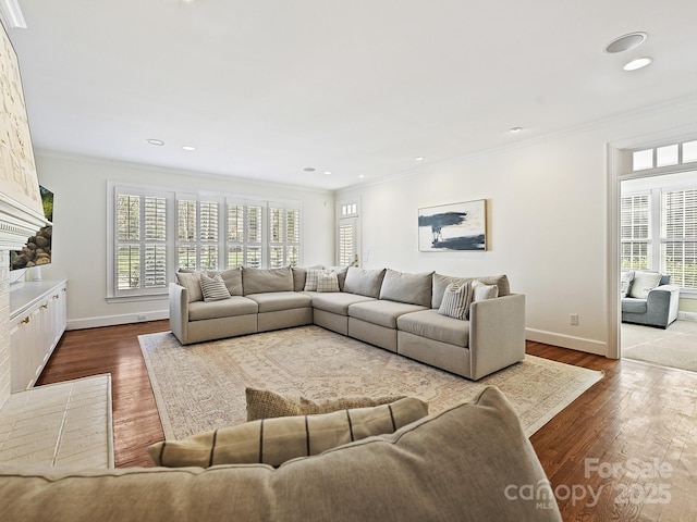 living area featuring a healthy amount of sunlight, baseboards, crown molding, and wood finished floors