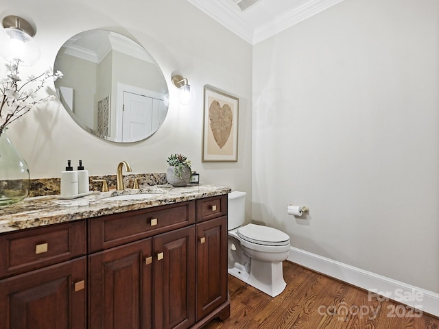 half bathroom with baseboards, toilet, ornamental molding, wood finished floors, and vanity