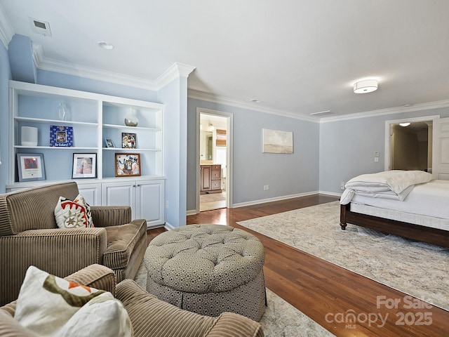 bedroom featuring crown molding, connected bathroom, baseboards, and wood finished floors