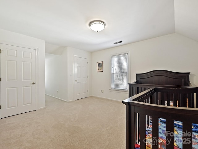 bedroom featuring lofted ceiling, visible vents, light carpet, and baseboards