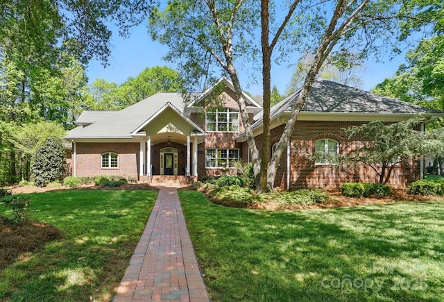 craftsman house featuring brick siding and a front yard