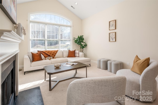 carpeted living room with a fireplace with flush hearth, baseboards, lofted ceiling, and visible vents