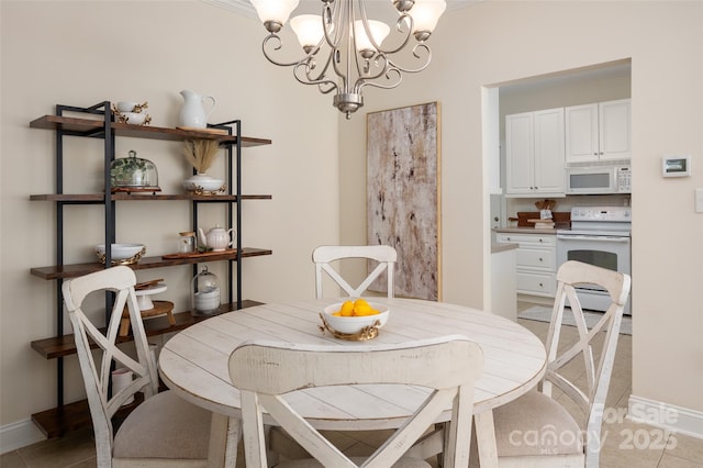 dining room with a notable chandelier, baseboards, and light tile patterned floors