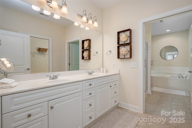 bathroom featuring tile patterned flooring, double vanity, visible vents, and a sink