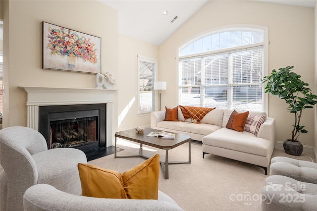 living room featuring visible vents, a fireplace with flush hearth, baseboards, and vaulted ceiling