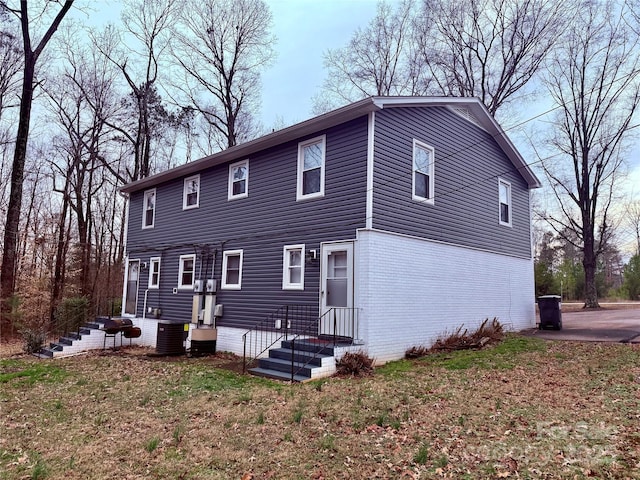 view of front of property with central AC unit and a front lawn